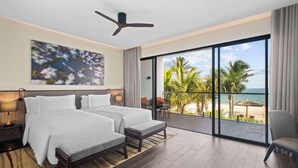 A hotel room with a large bed, a bench, a ceiling fan, and a view of the beach and ocean. - Angsana Ho Tram (Ho Chi Minh City)