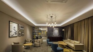 Ein modernes Wohnzimmer mit einer Couch, Sesseln, einem Couchtisch und einem Bücherregal.