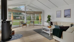 Una sala de estar moderna con un ventanal grande, una chimenea, un sofá y una mesa de centro.