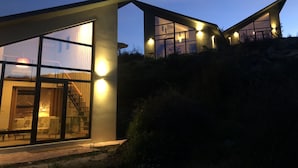 A modern house with large windows and a staircase leading to the entrance.