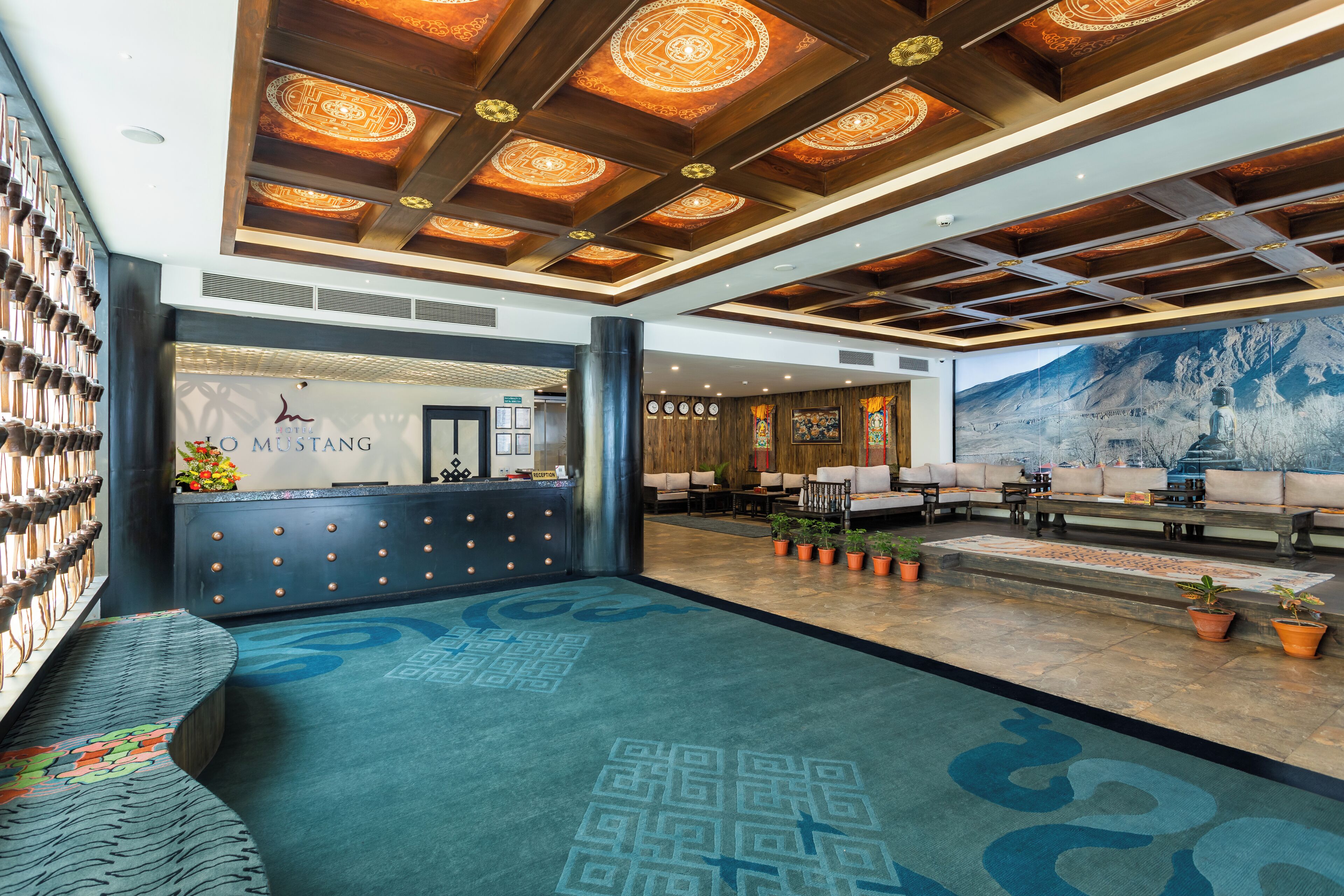 A lobby with a reception desk, seating area, and a large wall mural.