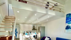 Un saló modern amb escala, zona de menjador i cuina.