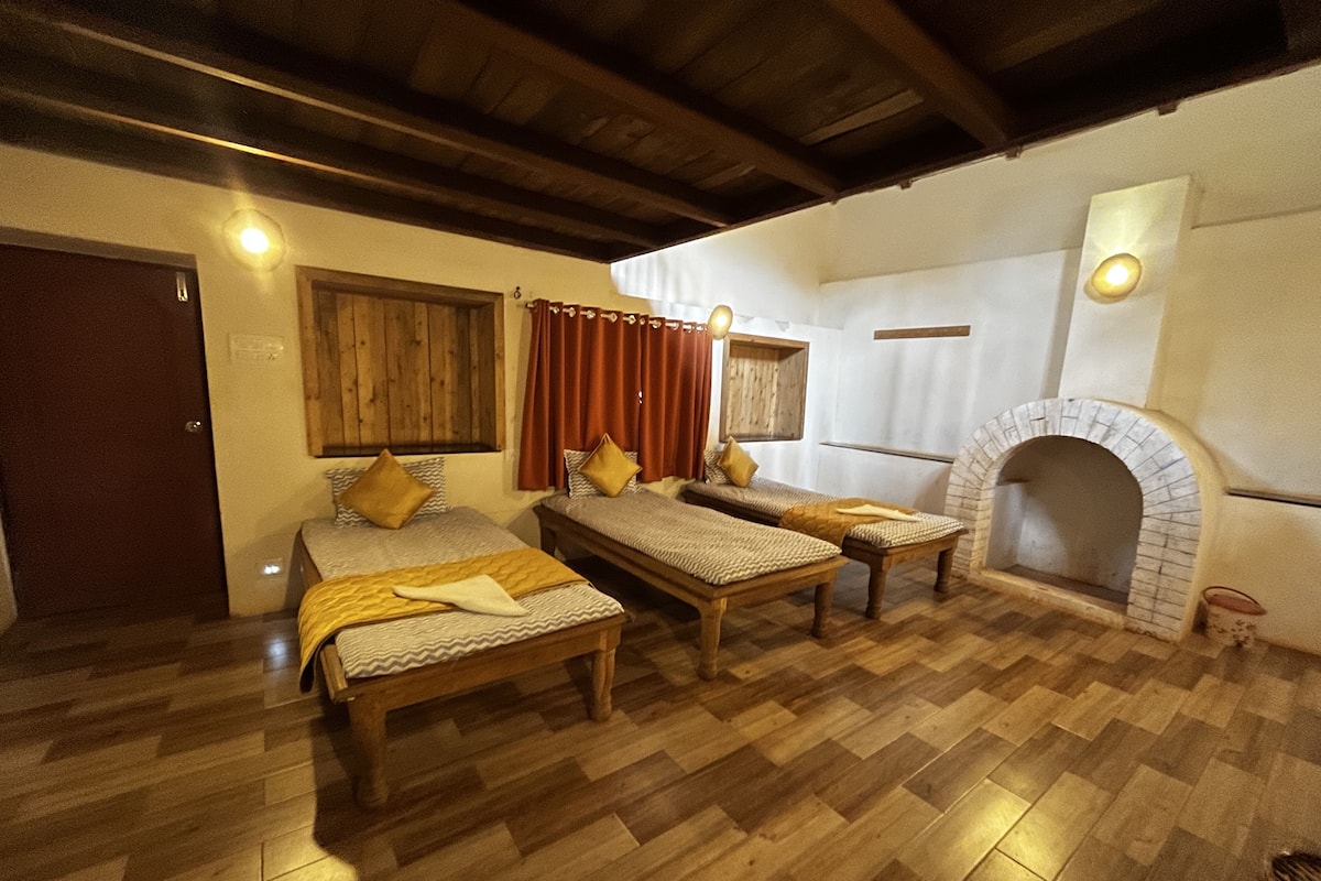 A cozy room with two wooden beds, a fireplace, and wooden flooring.