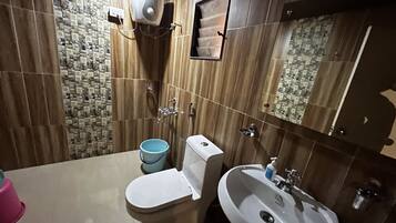 Un baño con inodoro, lavamanos y ducha.