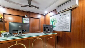 A reception desk with a computer, a monitor, and a signboard. - Treebo Marina Grand, Railway Station (Visakhapatnam)