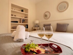 A neatly arranged breakfast tray with grapes, toast, and jam on a bed in a hotel room. - FX City Lover by LovelyStay (Funchal)