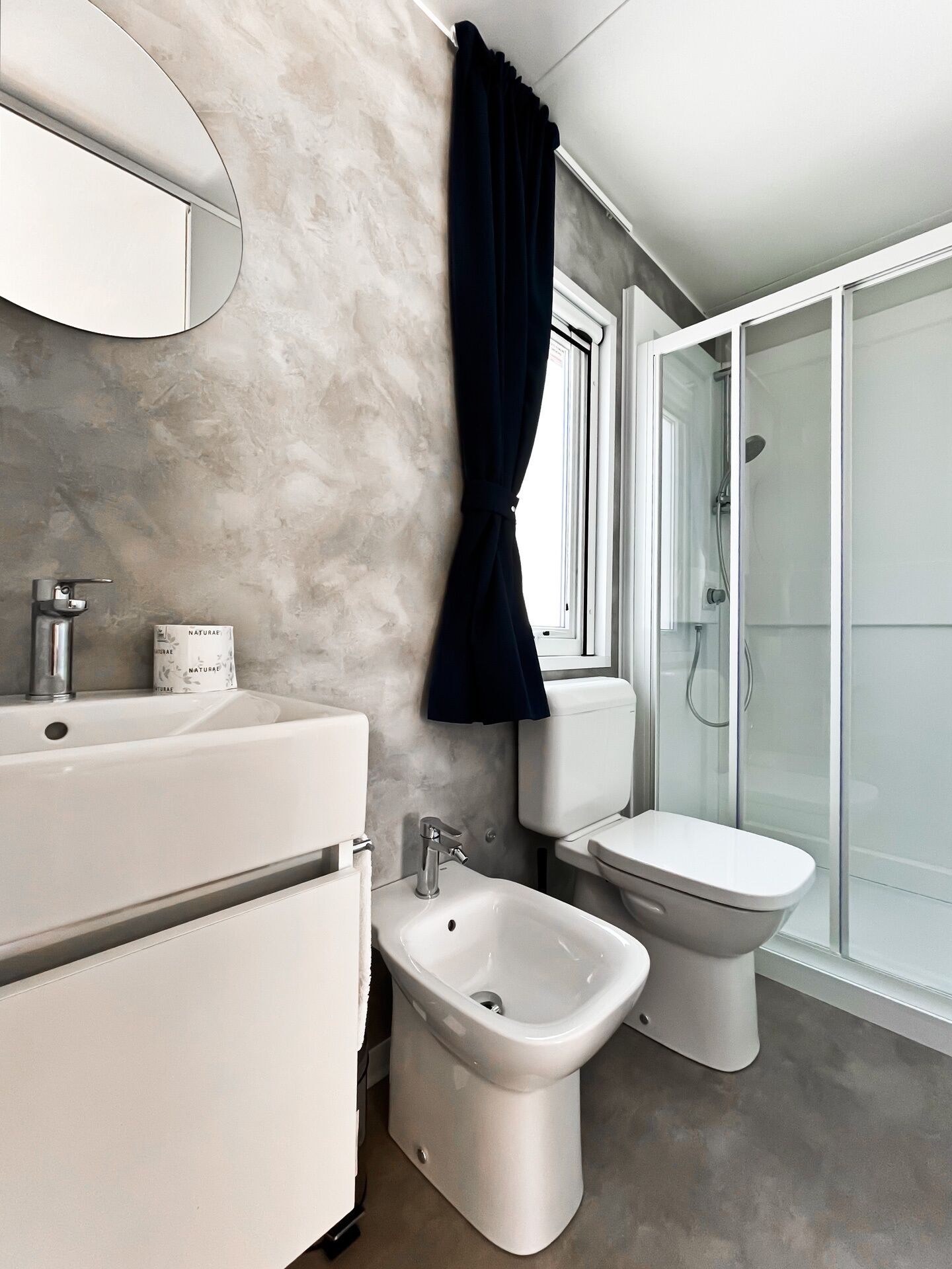 Ein modernes Badezimmer mit einer Bidet, Toilette und Waschbecken.