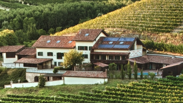 A large house with multiple sections, surrounded by lush green fields and vineyards. - Tenuta Cà dei Mandorli (Castel Boglione)