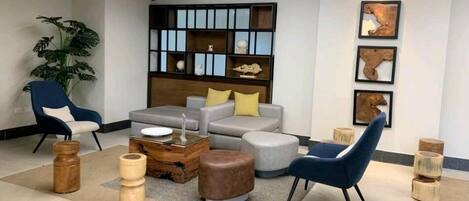 A modern living room with a grey sofa, blue armchairs, and a wooden coffee table.
