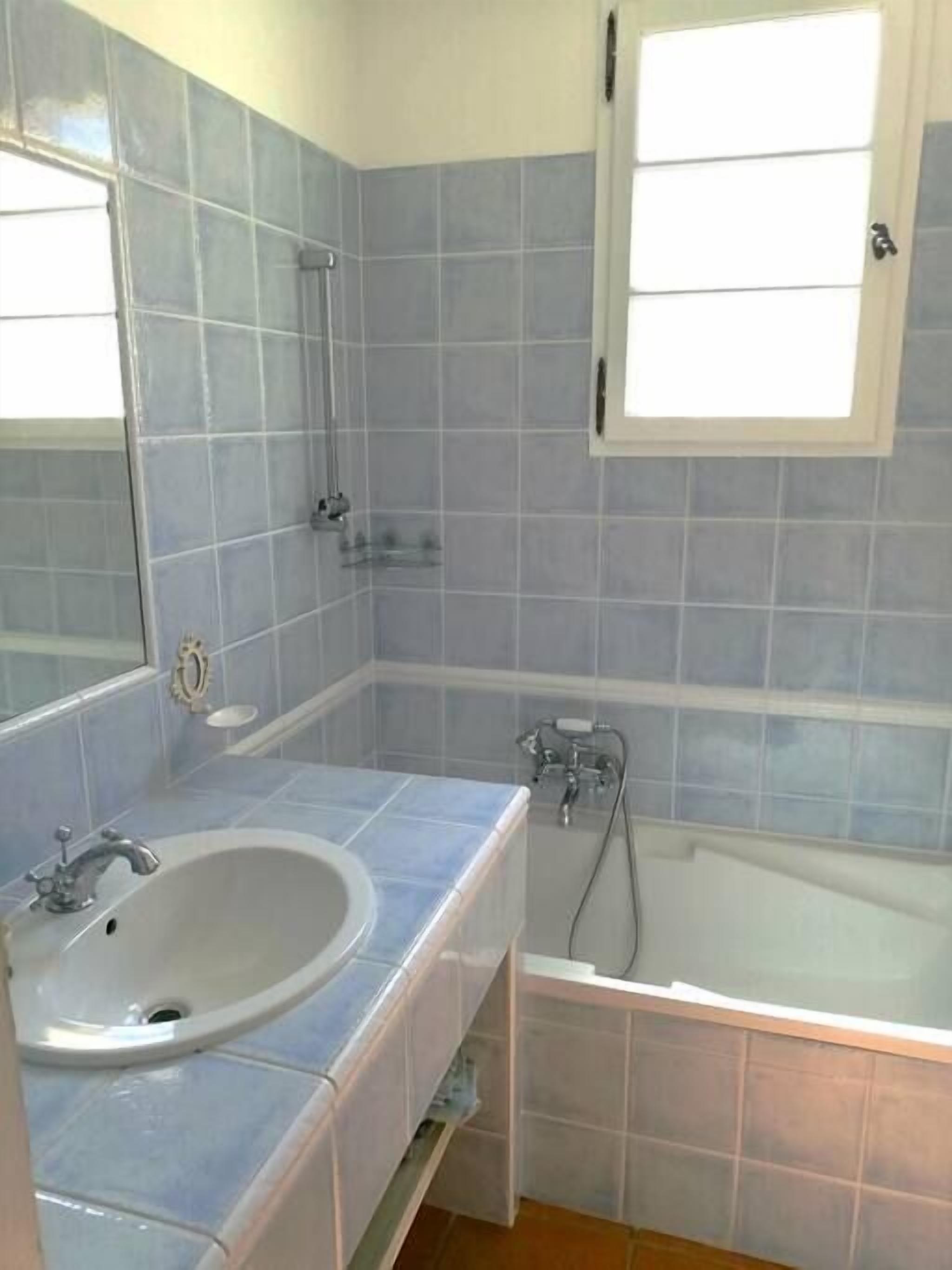 Un baño con lavamanos, espejo y bañera.