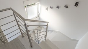 Un escalier moderne avec des rampes en métal, offrant une vue sur l’étage supérieur.