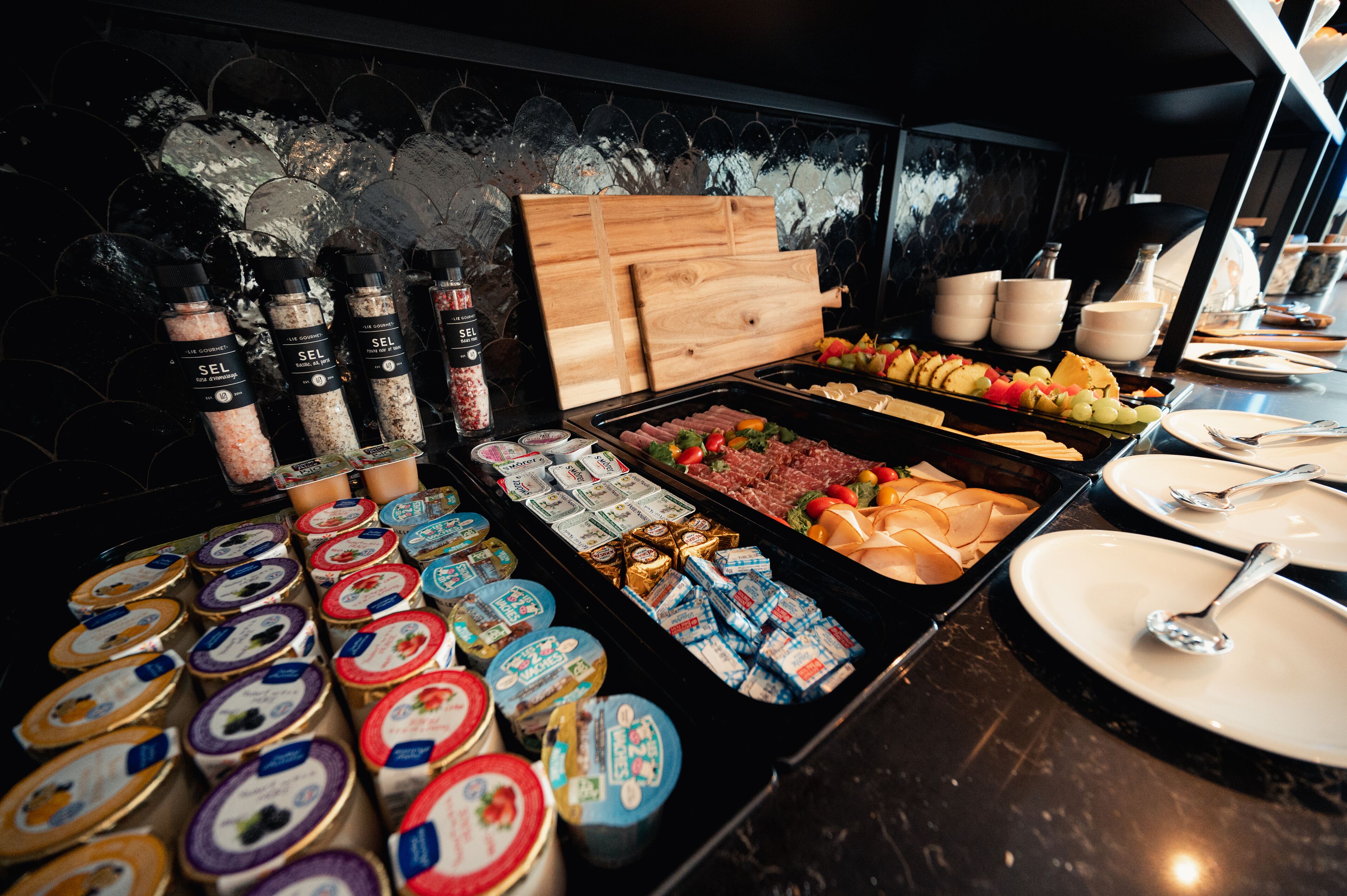 A buffet with various food items, condiments, and utensils.