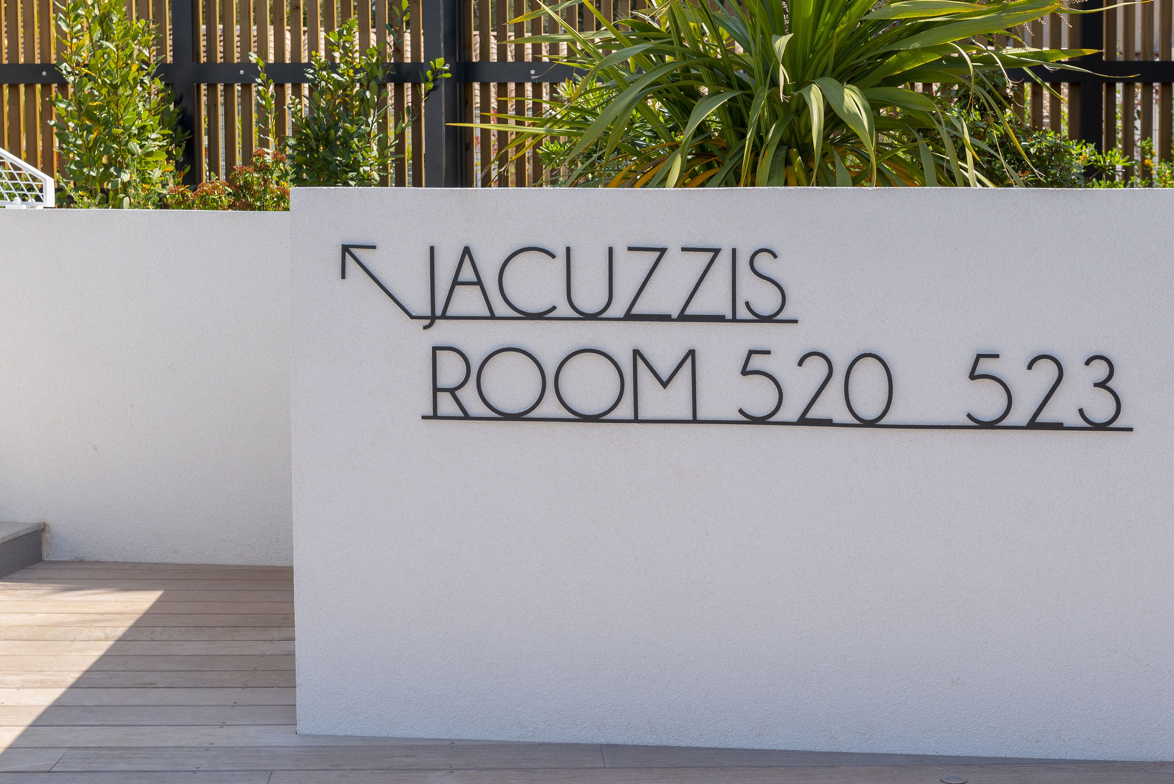 Señalización que indica 'JACUZZIS ROOMA 520 523' con una flecha señalando a la izquierda.