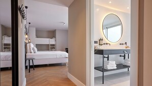 Une chambre moderne avec des lits superposés, une petite table et une lampe de chevet.