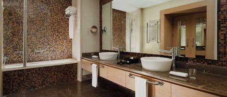 A modern bathroom with two sinks, a large mirror, and a shower area.