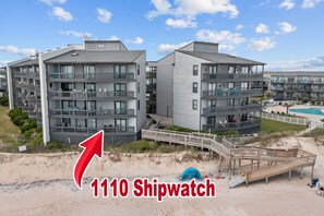 A beachfront hotel with multiple balconies, a pool, and a wooden boardwalk. - 3BR Oceanfront Condo in North Topsail Beach w/ Community Pool & Elevator (North Topsail Beach)