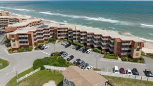 A beachfront hotel with multiple-story buildings, a parking lot, and ocean views. - 3BR Oceanfront Condo with Community Pool (North Topsail Beach)