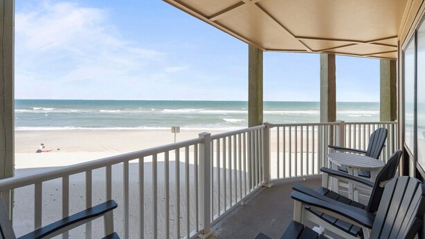 A covered balcony with a view of the beach and ocean. - 3BR Oceanfront Condo with Community Pool (North Topsail Beach)