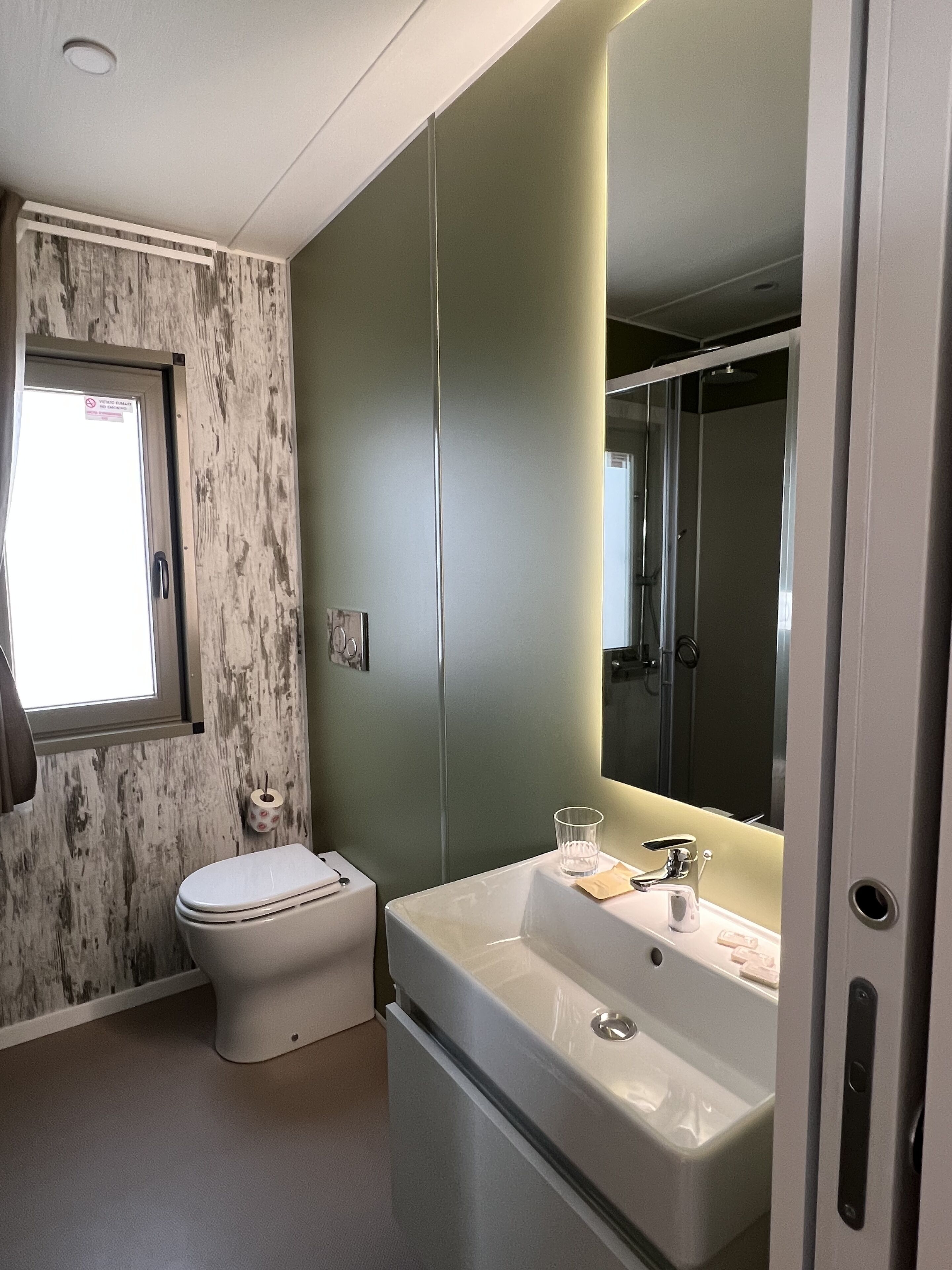 A modern bathroom with a toilet, sink, and shower.