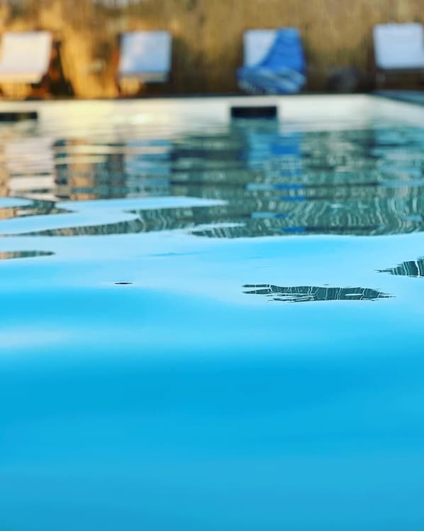A swimming pool with clear water and a tiled edge.