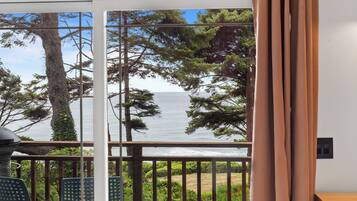 A balcony with a view of the sea and trees.