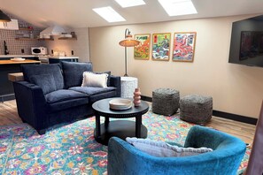 A living room with a sofa, a coffee table, and a patterned rug.