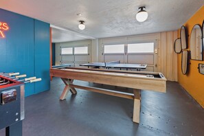A ping pong table in a room with a blue wall and a foosball table. - Ocean Front The Captain's Bounty @ Betty's Beachside, Stairs to the Beach! (Yachats)