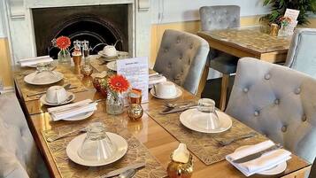 A dining area with a long table set for breakfast, including plates, cutlery, and a menu.
