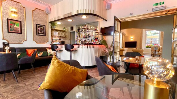 Un espace bar avec un comptoir, des sièges et une vue sur le bar.