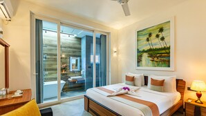 A hotel room with a large bed, a desk, a chair, a nightstand, a lamp, and a painting on the wall. - The Palace by Ocean (Ahungalla)