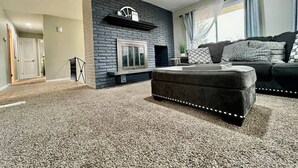 Una sala de estar con chimenea, un sofá y piso alfombrado.