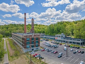 A parking lot with multiple cars and a building with a clock tower.