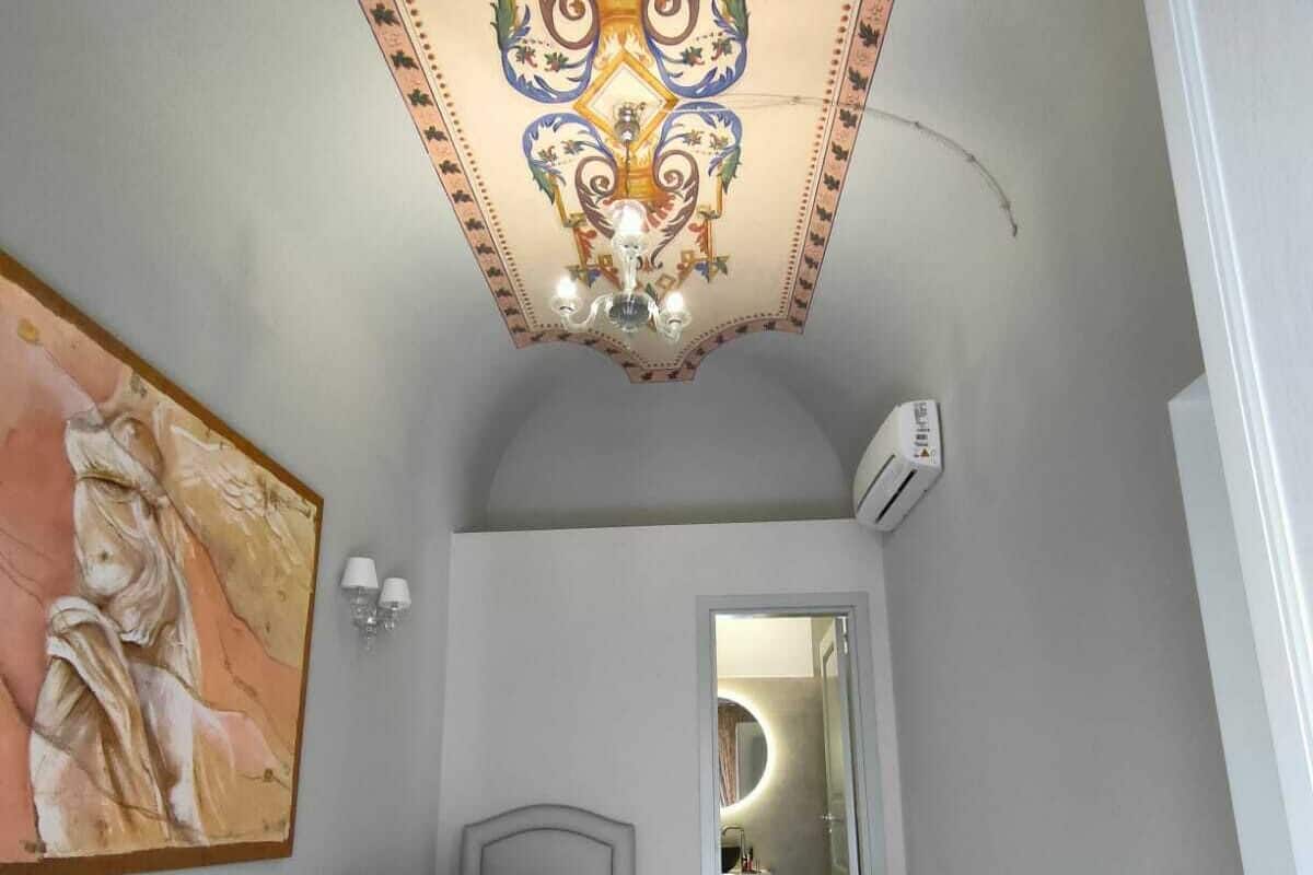 Un dormitorio con cama, un cuadro en la pared, un techo con diseño decorativo y un equipo de aire acondicionado.