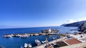 A coastal marina with boats docked, a small church, and a clear blue sky. - Lipari Suite  (Lipari)