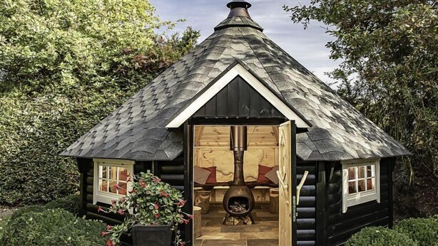 A log cabin with a chimney, a fireplace, and a door leading inside. - Het Landhuis by Interhome (Losser)