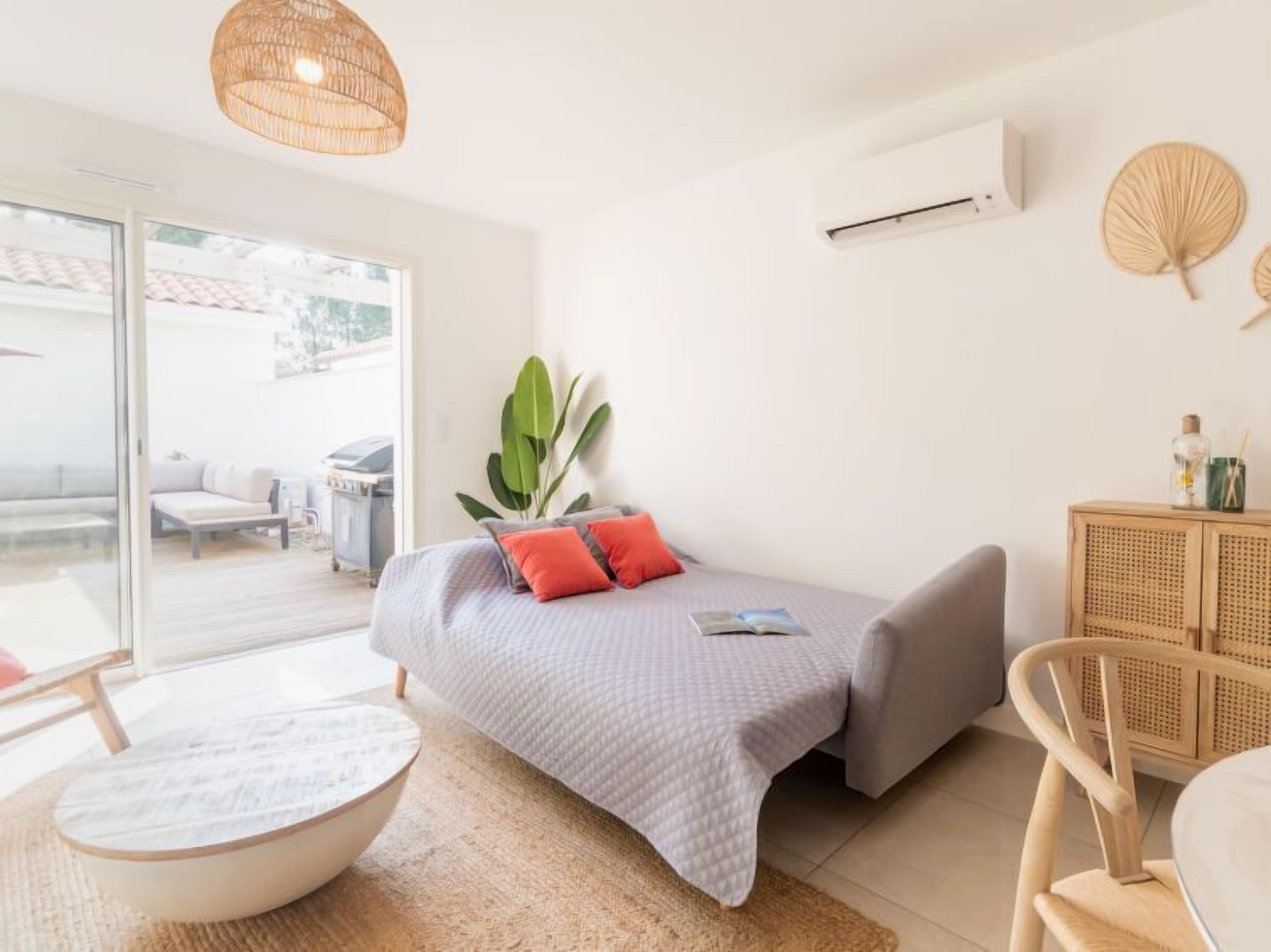 Un dormitorio moderno con una cama, una mesita, una silla y una planta en maceta.