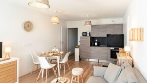 Un appartamento moderno con zona pranzo, cucina e soggiorno.