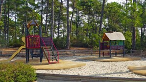 A playground with a slide, climbing structure, and a small shelter. - Les Grands Pins by Interhome (Maubuisson)
