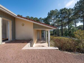 Um edifício térreo com varanda coberta, garagem e entrada por rampa.