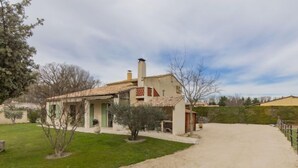 A two-story house with a tiled roof, a visible chimney, and a paved driveway leading to the entrance. - L'Aquillon by Interhome (Noves)