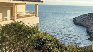 A coastal building with a balcony overlooking the sea, featuring a tiled roof and a view of the ocean. - Apartment Rits by Interhome (Salou)