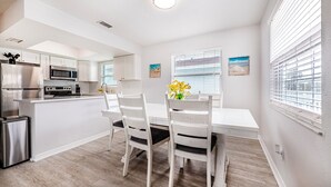 A modern kitchen with white cabinetry, stainless steel appliances, and a central island. - Spacious 2-bed, 2-bath second-floor unit minutes from Indian Rocks Beach. Sleeps nine with full kitchen, WiFi, smart TVs, parking, beach gear, and direct pool access. A bright, comfortable base for families and groups (Indian Rocks Beach)