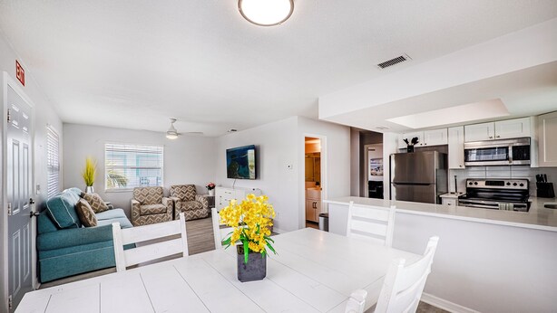 A modern kitchen with white cabinetry, a built-in oven, and a stainless steel refrigerator. - Spacious 2-bed, 2-bath second-floor unit minutes from Indian Rocks Beach. Sleeps nine with full kitchen, WiFi, smart TVs, parking, beach gear, and direct pool access. A bright, comfortable base for families and groups (Indian Rocks Beach)