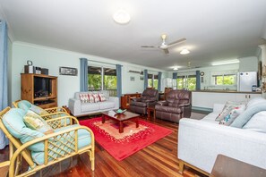 A living room with a sofa, chairs, a coffee table, and a television. - Ludbrookes (Nelly Bay)