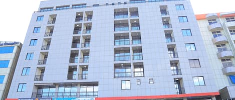 A multi-story hotel with a modern facade, featuring balconies on each floor and a prominent signage for the Sunland International Hotel.