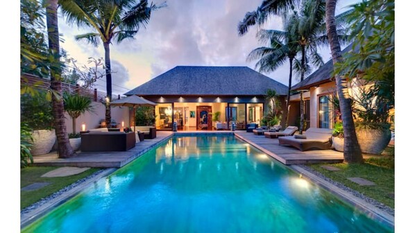 Relax by the resort's inviting pool surrounded by lush greenery and modern outdoor seating areas.