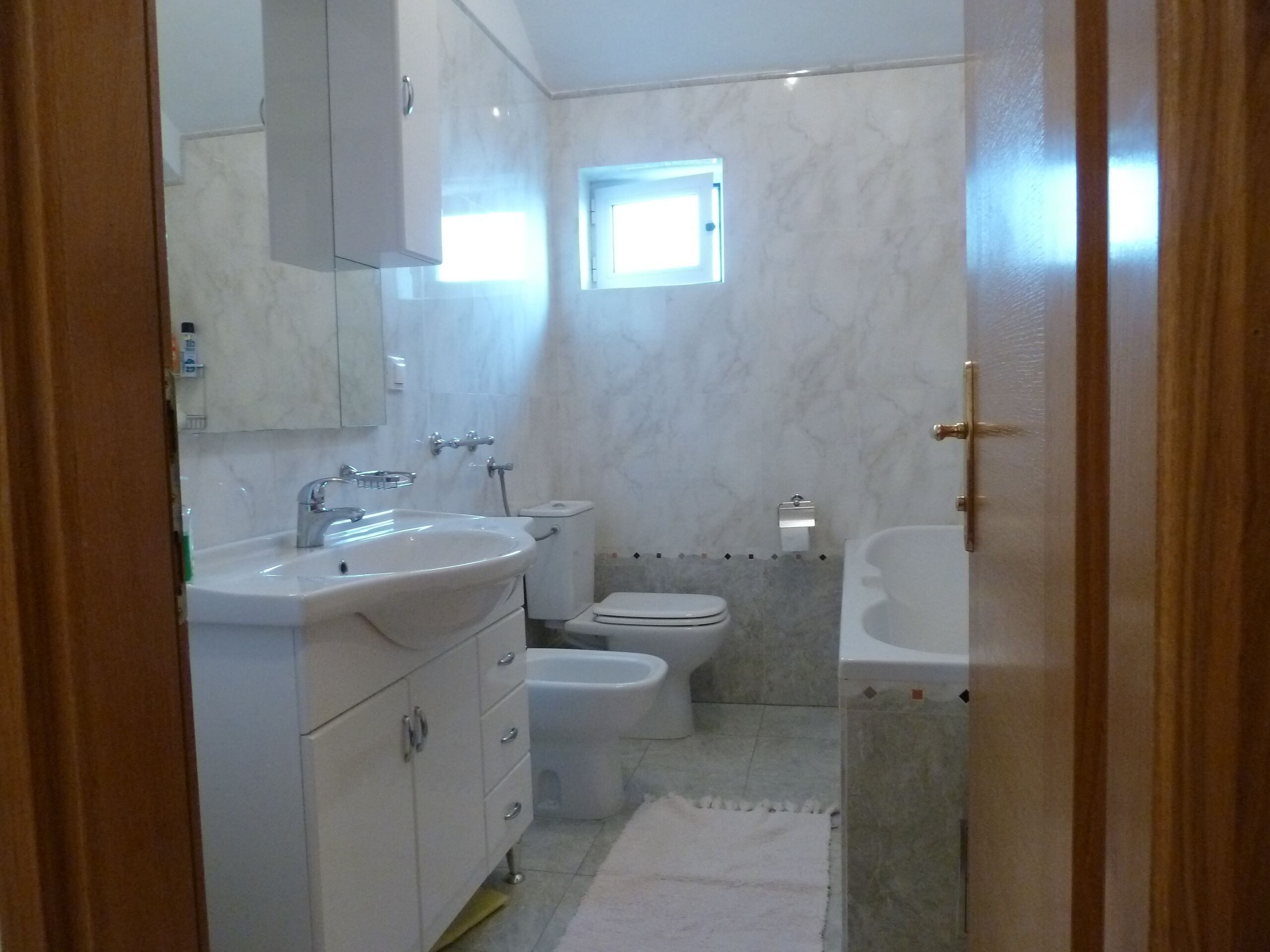 Een badkamer met een wastafel, toilet en bad.