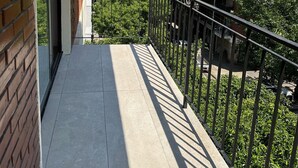 Ein Balkon mit Blick auf angrenzende Gebäude und Grünflächen.