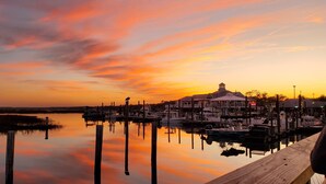 A marina with boats docked, a building with a dome, and a sunset sky. - Links And Shore 406: 4  BR, 3  BA Condominium in Garden City, Sleeps 12 (Garden City)