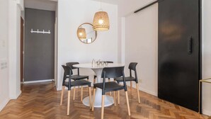 A dining area with a round table, black chairs, and two hanging light fixtures. - MOT Rentals + Anchorena 1400 - 2 Bd in Recoleta (Buenos Aires)